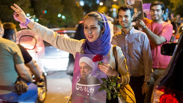 A woman holds a poster of Iranian President Hassan Rouhani during a campaign rally in Tehran, Iran, May 17, 2017 A woman holds a poster of Iranian President Hassan Rouhani during a campaign rally in Tehran, Iran, May 17, 2017 - Sputnik International