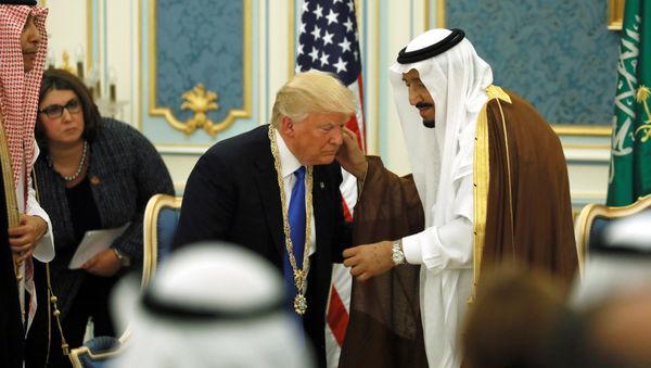 Saudi Arabia's King Salman bin Abdulaziz Al Saud (R) presents U.S. President Donald Trump (C) with the Collar of Abdulaziz Al Saud Medal at the Royal Court in Riyadh, Saudi Arabia May 20, 2017. Picture taken May 20, 2017 - Sputnik International