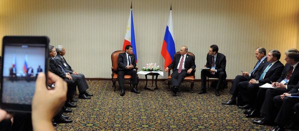 Russian President Vladimir Putin and Philippine President Rodrigo Duterte, background left, during a meeting on the sidelines of the APEC summit in Lima on November 19, 2016 Russian President Vladimir Putin and Philippine President Rodrigo Duterte, background left, during a meeting on the sidelines of the APEC summit in Lima on November 19, 2016 - Sputnik International