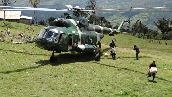 A rescue worker unloads supplies from a Peruvian Air Force helicopter at a camp set up near the cave where an injured Spanish speleologist remains trapped, in Leimebamba, Peru, Friday, Sept. 26, 2014 - Sputnik International