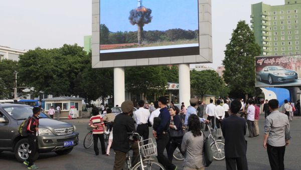 People watch a news broadcast on the launch of the solid-fuel Pukguksong-2 missile on a screen in front of the railway station in Pyongyang, North Korea, Monday, May 22, 2017. - Sputnik International