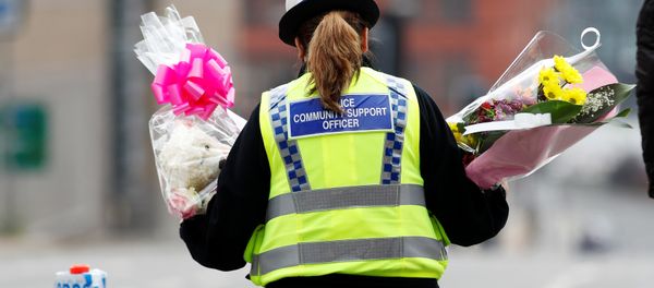 A community support officer carries flowers near Manchester Arena in Manchester, Britain May 24, 2017. A community support officer carries flowers near Manchester Arena in Manchester, Britain May 24, 2017. - Sputnik International
