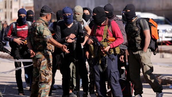 Rebel fighters carry their weapons and belongings as they talk to a Syrian army soldier, as rebel fighters and their families evacuate the besieged Waer district in the central Syrian city of Homs, after an agreement was reached between rebels and Syria's army, Syria May 21, 2017 - Sputnik International
