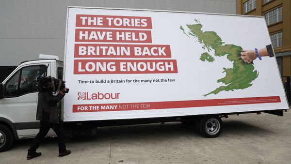 A cameraman films a poster unveiled by Britain's opposition Labour party for the upcoming general election, which their party leader Jeremy Corbyn did not attend, in London, Thursday, May 11, 2017 - Sputnik International