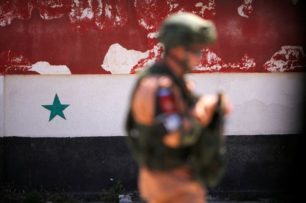A Russian soldier stands guard near a Syrian national flag drawn on the wall as rebel fighters and their families evacuate the besieged Waer district in the central Syrian city of Homs, after an agreement reached between rebels and Syria's army, Syria May 21, 2017 A Russian soldier stands guard near a Syrian national flag drawn on the wall as rebel fighters and their families evacuate the besieged Waer district in the central Syrian city of Homs, after an agreement reached between rebels and Syria's army, Syria May 21, 2017 - Sputnik International