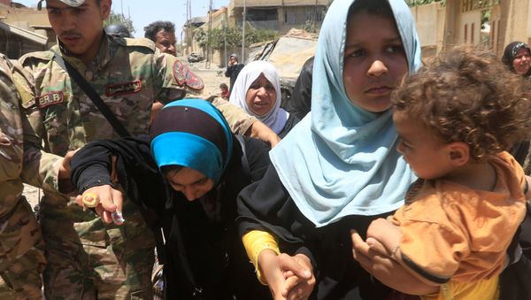 Iraqi rapid response forces help displaced Iraqi women who fled homes during a fight between Iraqi forces and Islamic State militants in al-Zanjili neighbourhood, north of Old City district of Mosul, Iraq May 30, 2017. Iraqi rapid response forces help displaced Iraqi women who fled homes during a fight between Iraqi forces and Islamic State militants in al-Zanjili neighbourhood, north of Old City district of Mosul, Iraq May 30, 2017. - Sputnik International