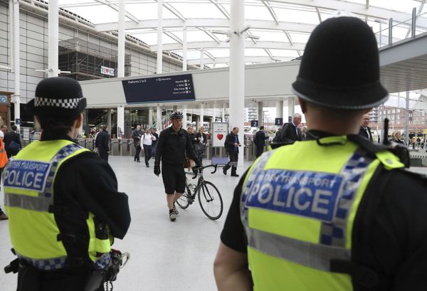Police watch as commuters pass through Manchester Victoria railway station in Manchester England, which has reopened for the first time since the terror attack on the adjacent Manchester Arena Tuesday May 30, 2017 - Sputnik International