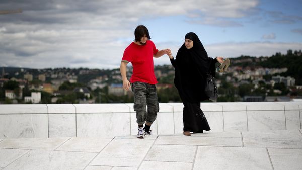 A man helps a woman up a step on the roof of the Opera house in Oslo A man helps a woman up a step on the roof of the Opera house in Oslo - Sputnik International