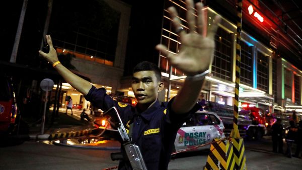A security guard stops photographers from entering the vicinity of Resorts World Manila after gunshots and explosions were heard in Pasay City, Metro Manila, Philippines June 2, 2017. - Sputnik International