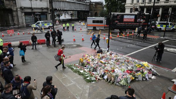 A woman places a rose with other floral tributes for the victims of the attack on London Bridge and Borough Market at London Bridge, London, Britain June 6, 2017 - Sputnik International