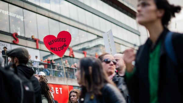 People hold signs reading 'refugees welcome' as they take part in demonstration in solidarity with migrants seeking asylum in Europe after fleeing their home countries in Stockholm (File) - Sputnik International