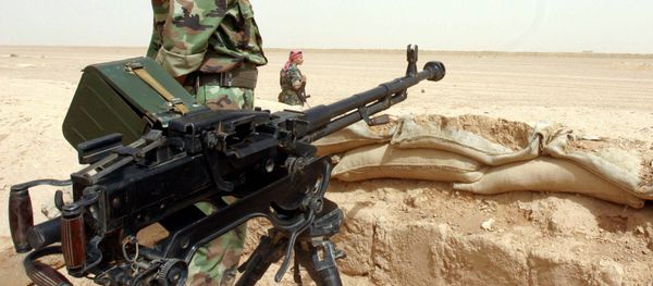 A Syrian soldier stands next to his machingun at a border post in the desert, on the Syrian side of the  border with Iraq (File) - Sputnik International