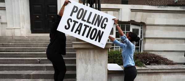 Workers prepare signs outside their polling station on general election day in London, britain, June 8, 2017. Workers prepare signs outside their polling station on general election day in London, britain, June 8, 2017. - Sputnik International