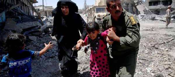 Iraqi soldiers help residents displaced by fighting between Iraqi forces and Islamic State militants in Mosul's al-Zanjili's district, Iraq June 7, 2017. - Sputnik International