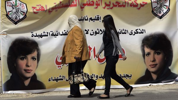 Palestinian women walk past a banner in the West bank town of Bireh, which pictures Fatah member Dalal Mughrabi, who led an attack on an Israeli bus near Tel Aviv, killing 36 people in 1978 Palestinian women walk past a banner in the West bank town of Bireh, which pictures Fatah member Dalal Mughrabi, who led an attack on an Israeli bus near Tel Aviv, killing 36 people in 1978 - Sputnik International