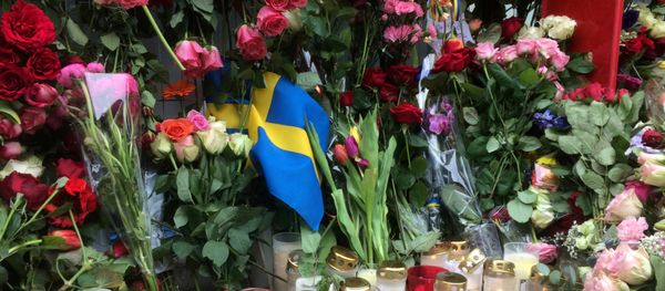 Sweden's flag is seen among flowers near the crime scene in central Stockholm April 8, 2017, the day after a hijacked beer truck plowed into pedestrians on Drottninggatan and crashed into Ahlens department store. Sweden's flag is seen among flowers near the crime scene in central Stockholm April 8, 2017, the day after a hijacked beer truck plowed into pedestrians on Drottninggatan and crashed into Ahlens department store. - Sputnik International