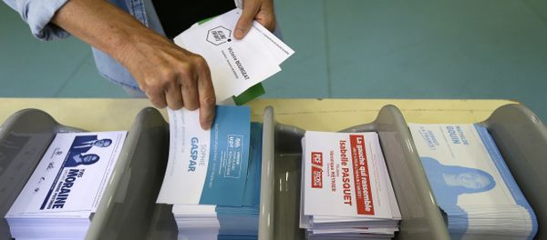 Voter picks up ballots at a polling station before voting for the first round of parliamentary elections in Marseille, southern France, Sunday, June 11, 2017 Voter picks up ballots at a polling station before voting for the first round of parliamentary elections in Marseille, southern France, Sunday, June 11, 2017 - Sputnik International