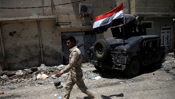 A member of the Iraqi Army's 9th Armoured Division walks past an armoured vehicle at the frontline in western Mosul, Iraq June 12, 2017 A member of the Iraqi Army's 9th Armoured Division walks past an armoured vehicle at the frontline in western Mosul, Iraq June 12, 2017 - Sputnik International