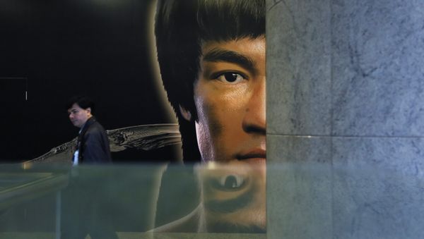 A man walks past a promotional poster of Bruce Lee's memorial exhibition at the Hong Kong Heritage Museum in Hong Kong, Monday, March 31, 2014, to mark the 40th anniversary of the death of Lee - Sputnik International