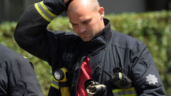 Firefighters rest near a tower block, severely damaged in a serious fire, in north Kensington, West London, Britain June 14, 2017. - Sputnik International