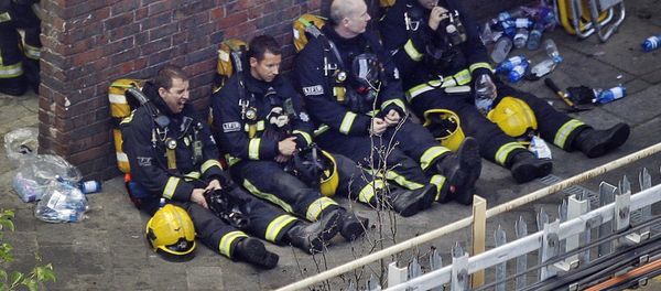 Firefighters rest as they take a break in battling a massive fire that raged in a high-rise apartment building in London, Wednesday, June 14, 2017. - Sputnik International