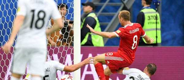 From left: Russia's Denis Glushakov scores a goal during the 2017 FIFA Confederations Cup match between Russia and New Zealand. Right: New Zealand's Tommy Smith - Sputnik International
