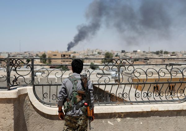 A Kurdish fighter from the People's Protection Units (YPG) looks at a smoke after an coalition airstrike in Raqqa, Syria June 16, 2017 - Sputnik International