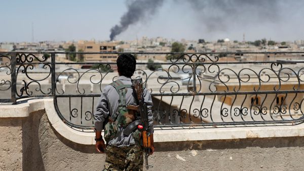 A Kurdish fighter from the People's Protection Units (YPG) looks at a smoke after an coalition airstrike in Raqqa, Syria June 16, 2017 A Kurdish fighter from the People's Protection Units (YPG) looks at a smoke after an coalition airstrike in Raqqa, Syria June 16, 2017 - Sputnik International