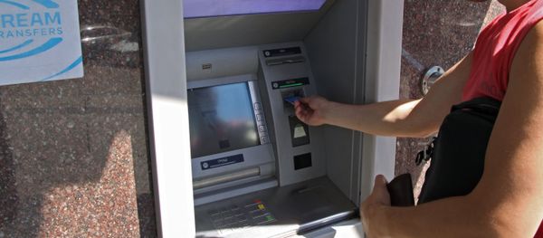 A city resident at a cash dispenser operated by the Central Republican Bank in Donetsk A city resident at a cash dispenser operated by the Central Republican Bank in Donetsk - Sputnik International