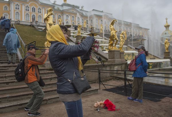 Tourists pose for photographs against the background of the Grand Cascade fountains during the opening of the summer season at the Peterhof museum-reserve Tourists pose for photographs against the background of the Grand Cascade fountains during the opening of the summer season at the Peterhof museum-reserve - Sputnik International