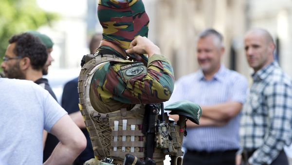 A Belgian Army soldier adjusts his face mask as he patrols outside the prime ministers office in Brussels on Wednesday, June 21, 2017. - Sputnik International