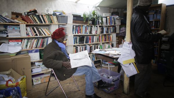 Migrant reads a newspaper in a public library (File) - Sputnik International
