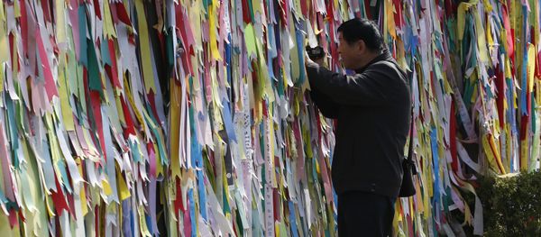A visitor films through a wire fence decorated with ribbons carrying messages visitors left wishing for the reunification of the two Koreas at the Imjingak Pavilion near the border with North Korea, in Paju, in Seoul, South Korea, Friday, April 15, 2016 A visitor films through a wire fence decorated with ribbons carrying messages visitors left wishing for the reunification of the two Koreas at the Imjingak Pavilion near the border with North Korea, in Paju, in Seoul, South Korea, Friday, April 15, 2016 - Sputnik International