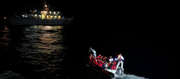 Fiorillo Italian Coast Guard vessel officers transfer migrants being rescued by Save the Children NGO crew from the ship Vos Hestia, in the Mediterranean sea off the Libyan coast, June 16, 2017 Fiorillo Italian Coast Guard vessel officers transfer migrants being rescued by Save the Children NGO crew from the ship Vos Hestia, in the Mediterranean sea off the Libyan coast, June 16, 2017 - Sputnik International