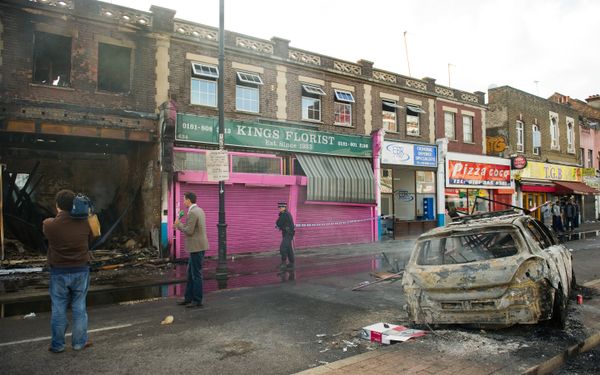A police officer sets up a cordon around a burnt-out shop on High Road in Tottenham, north London on August 7, 2011. A police officer sets up a cordon around a burnt-out shop on High Road in Tottenham, north London on August 7, 2011. - Sputnik International
