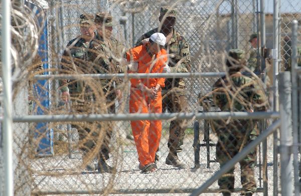 A detainee from Afghanistan is led by military police with his hands chained at Camp X-Ray at the U.S. Naval Base in Guantanamo Bay, Cuba, in this Feb. 2, 2002, file photo - Sputnik International