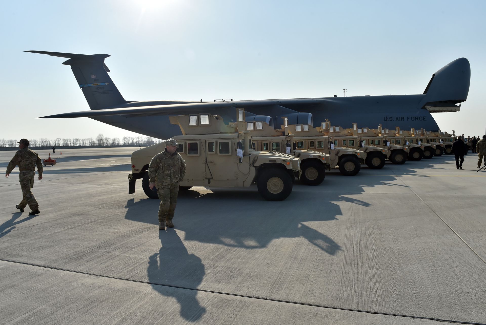 Ukrainian servicemen walk in front of armoured cars at Kiev airport on March 25, 2015 during a welcoming ceremony of the first US plane delivery of non-lethal aid, including 10 Humvee vehicles. - Sputnik International, 1920, 21.10.2022