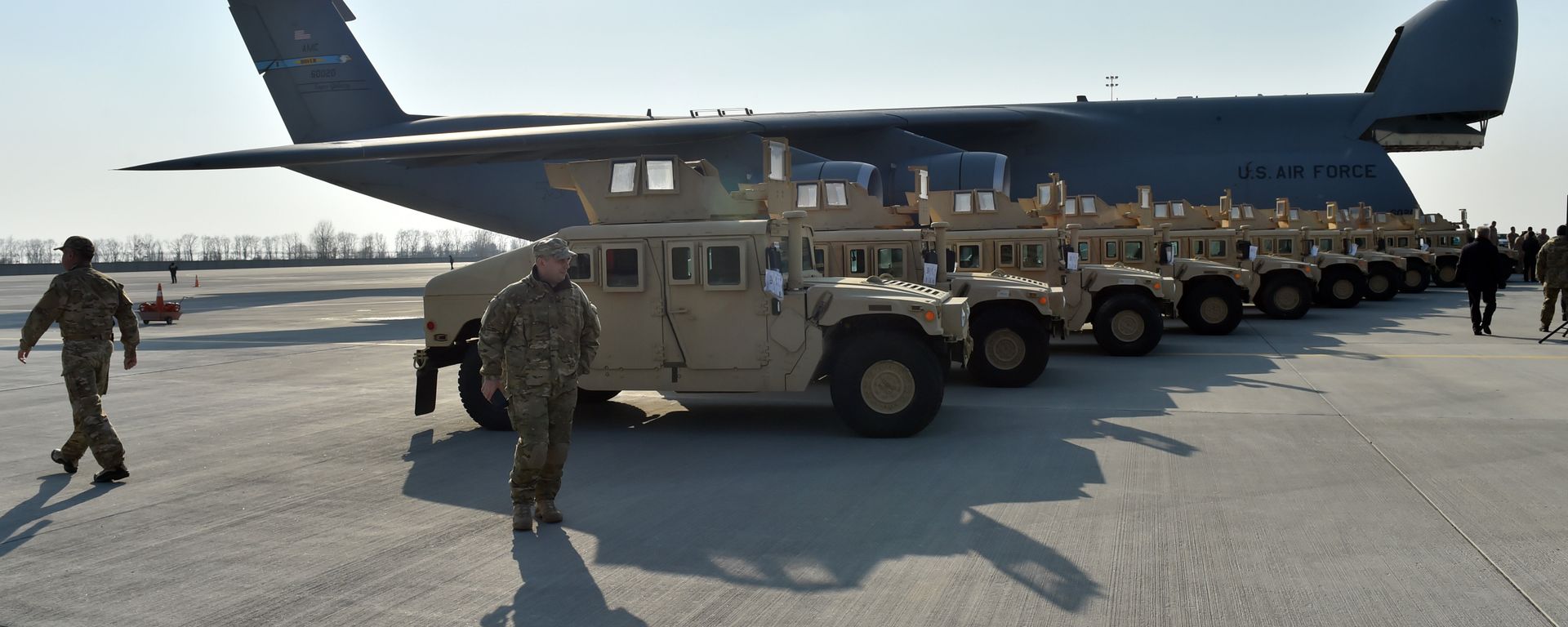 Ukrainian servicemen walk in front of armoured cars at Kiev airport on March 25, 2015 during a welcoming ceremony of the first US plane delivery of non-lethal aid, including 10 Humvee vehicles. Ukrainian servicemen walk in front of armoured cars at Kiev airport on March 25, 2015 during a welcoming ceremony of the first US plane delivery of non-lethal aid, including 10 Humvee vehicles. - Sputnik International, 1920, 13.12.2023