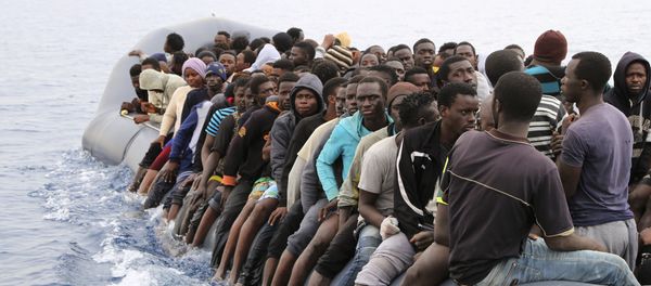 Migrants wait to be rescued from a sinking dingey off the Libyan coasal town of Zawiyah, east of the capital, on March 20, 2017, as they attempted to cross from the Mediterranean to Europe. - Sputnik International