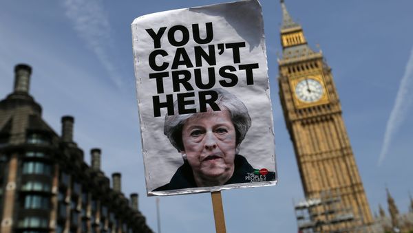 A placard showing a picture of Britain's Prime Minister Theresa May, saying You can't trust her is raised in front of the Elizabeth Tower, commonly referred to as Big Ben as protesters gather in Parliament Square after marching through central London on June 21, 2017. A placard showing a picture of Britain's Prime Minister Theresa May, saying You can't trust her is raised in front of the Elizabeth Tower, commonly referred to as Big Ben as protesters gather in Parliament Square after marching through central London on June 21, 2017. - Sputnik International