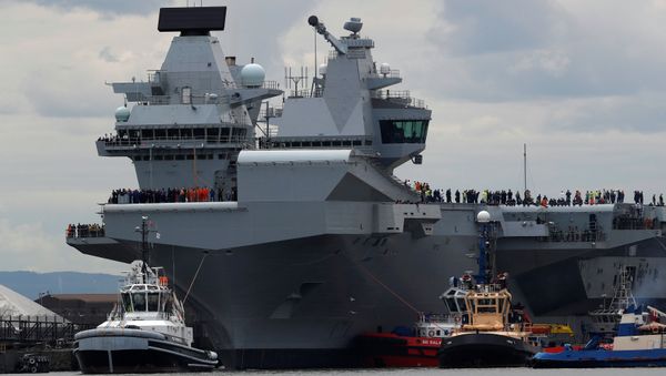 The British aircraft carrier HMS Queen Elizabeth is pulled from its berth by tugs before its maiden voyage, in Rosyth, Scotland, Britain June 26, 2017. - Sputnik International