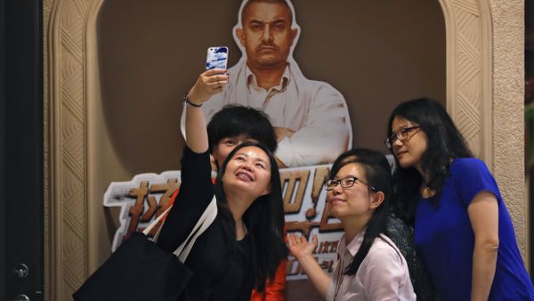 Chinese women take a selfie with a poster of Indian Bollywood blockbuster film Dangal on display at a cinema in Beijing. Chinese women take a selfie with a poster of Indian Bollywood blockbuster film Dangal on display at a cinema in Beijing. - Sputnik International