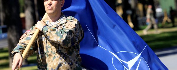 A Latvian Army soldier walks with the NATO flag during the official welcoming ceremony of the NATO Canadian-led Enhanced Forward Presence (EFP) combat battalion in Adazi, Latvia June 19, 2017 - Sputnik International