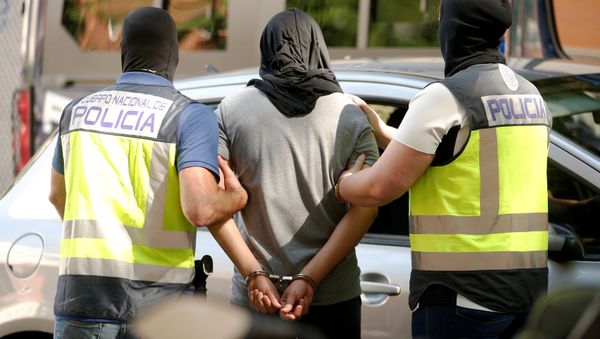 Police lead away a suspect from an apartment block during a raid in which they arrested a 32-year-old Moroccan they said was highly radicalised, in Madrid, Spain June 21, 2017 - Sputnik International