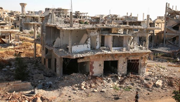 A rebel fighter walks past damaged buildings in a rebel-held part of the southern city of Deraa, Syria June 22, 2017 - Sputnik International
