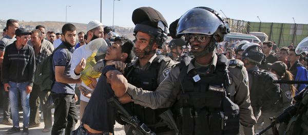 Israeli border police detain a Palestinian youth as crowds make their way through the Israeli Qalandia checkpoint, in the occupied West Bank between Ramallah and Jerusalem, to attend Friday prayer of the holy fasting month of Ramadan in Jerusalem's al-Aqsa mosque, on June 16, 2017 - Sputnik International
