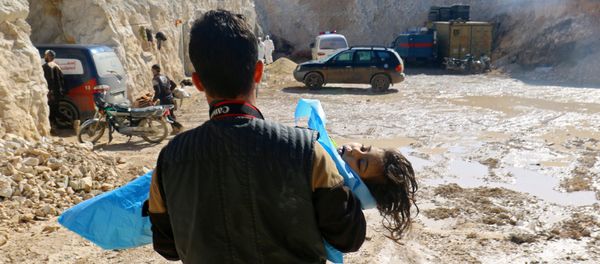 A man carries the body of a dead child, after what rescue workers described as a suspected gas attack in the town of Khan Sheikhoun in rebel-held Idlib, Syria April 4, 2017 - Sputnik International