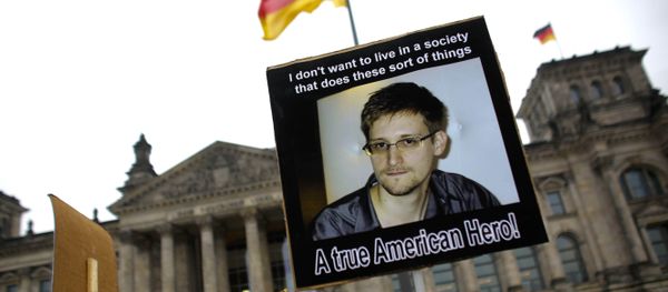 Protesters hold posters of former National Security Agency member Edward Snowden in front of the German parliament building, the Reichstag, prior to a special meeting of the parliament on US-German relationships, in Berlin, Monday, Nov. 18, 2013 - Sputnik International