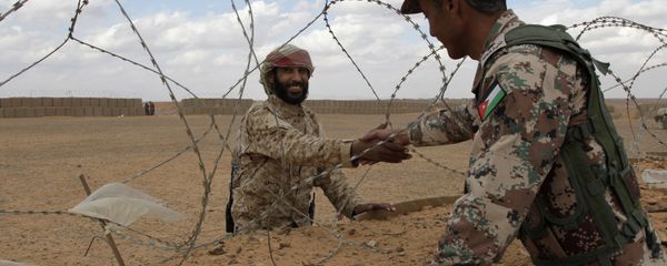 A member of the Syrian Tribes Army, left, that guards the Syrian side of the berm on the north eastern border with Jordan, shakes hands with a Jordanian soldier (File) - Sputnik International