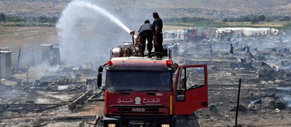 Civil defence members put out fire at a camp for Syrian refugees near the town of Qab Elias, in Lebanon's Bekaa Valley Civil defence members put out fire at a camp for Syrian refugees near the town of Qab Elias, in Lebanon's Bekaa Valley - Sputnik International